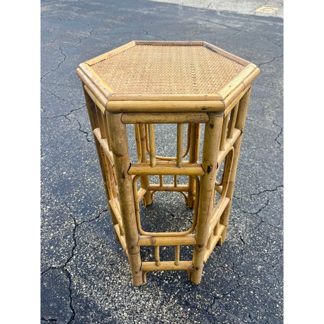 Charming vintage bamboo and woven cane side table featuring a distinctive hexagonal top and architectural openwork frame....