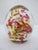 Collectible egg-shaped glass paperweight featuring vibrant swirls of red and yellow suspended in clear blown glass....