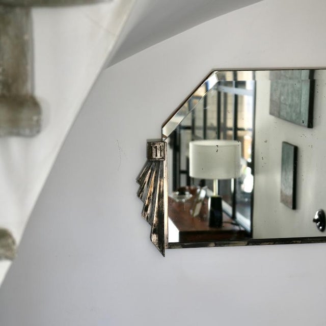A vintage Art Deco wall mirror, made in France in the 1930s or 40s. It is distinguished by its structured silhouette and...