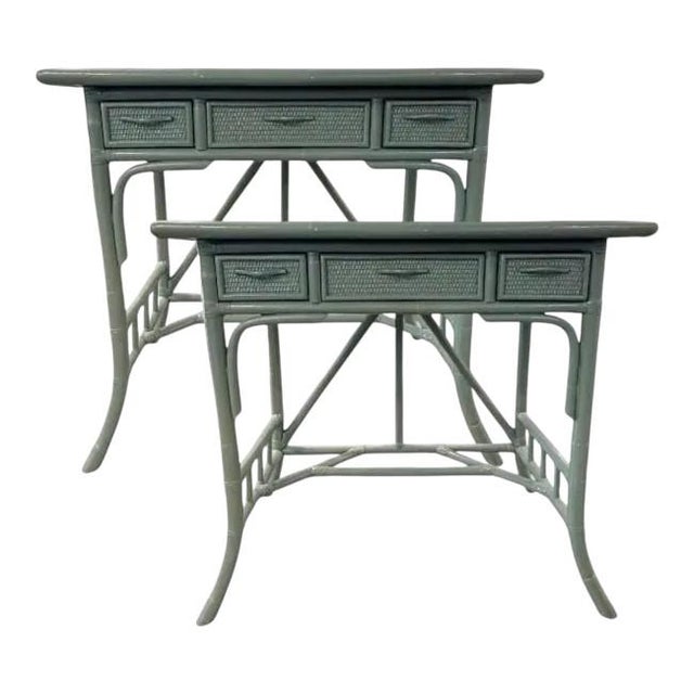 Charming pair of vintage rattan side tables featuring a sculptural bamboo-style frame and woven drawer fronts. Finished in...
