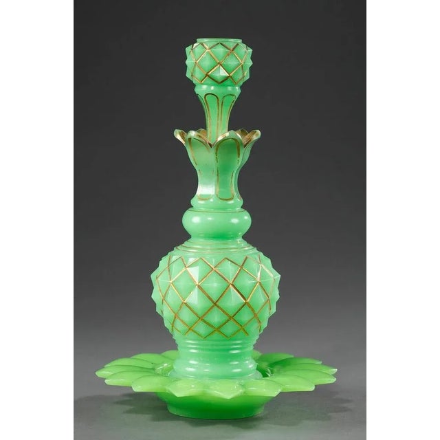 Pair of green opaline perfume flasks with pointed stoppers and flower-shaped saucers. The stoppers and flasks are...