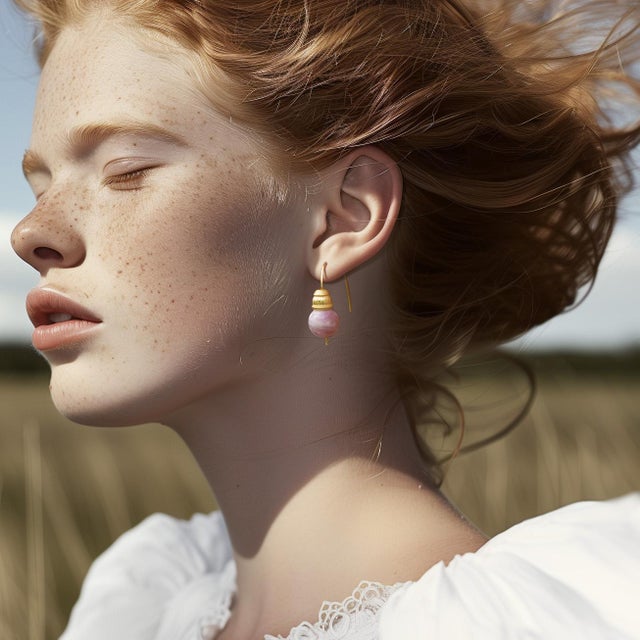 Soft whispers of rose-colored stone crowned with intricate golden detail, these earrings hold the gentle warmth of sunset...