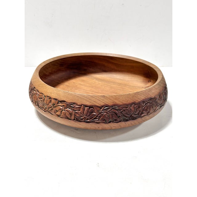 A beautifully hand-carved 1970s wooden bowl featuring a deeply carved floral band wrapping the exterior and additional...