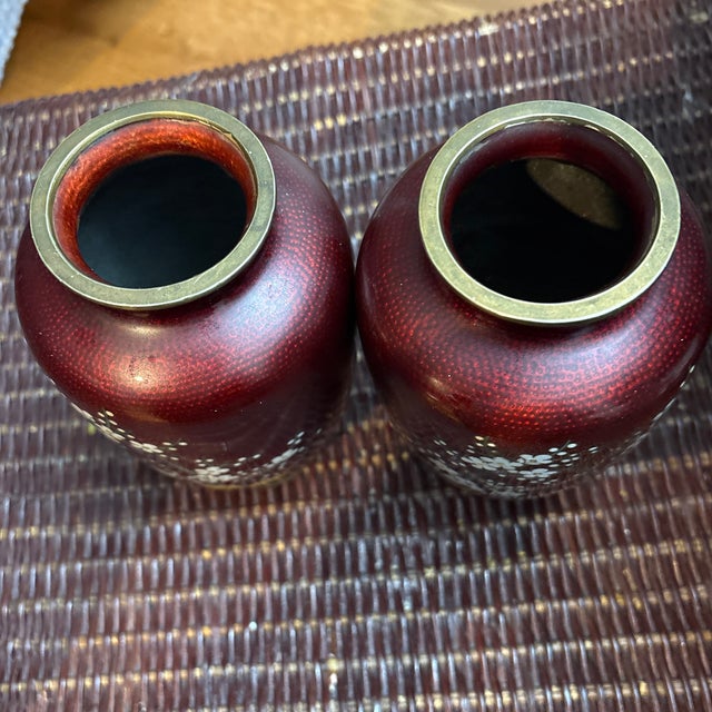 These are a pair of Japanese ginbari cloisonné vases, likely by the Sato company. The vases feature a deep "pigeon blood"...
