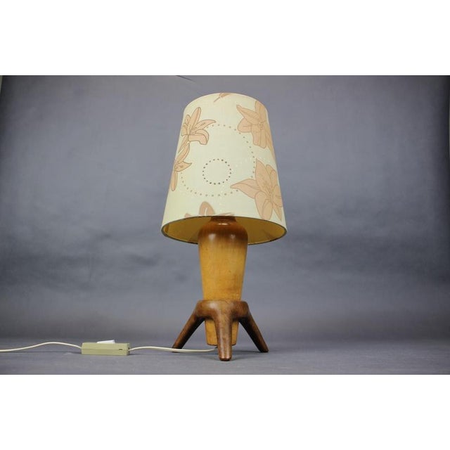 Vintage ULUV table lamp manufactured in Czechoslovakia during the 1960s. The lamp features a sculptural wooden tripod base...