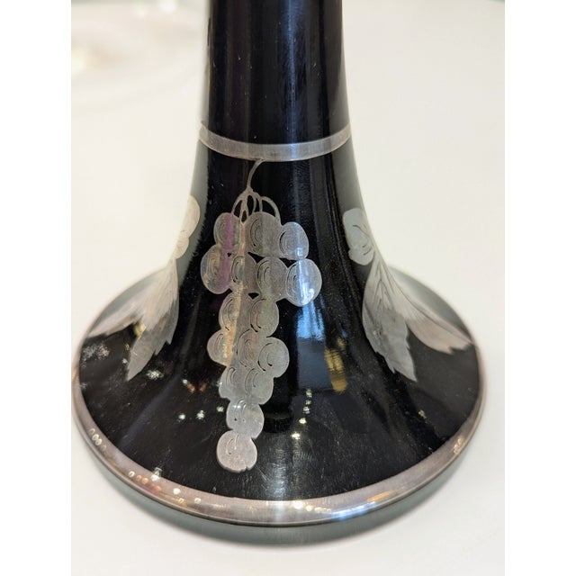 Pair of black amethyst glass candlesticks with silver overlay, circa 1930s–1950s. These pieces exemplify the Art Deco...