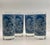 A set of four blue and white line-work tumblers featuring a charming forested farmstead vignette set in a a frame of...