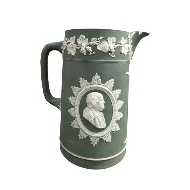 Large antique Wedgwood Jasperware pitcher featuring classical white relief medallions, grapevine garlands, and elegant...