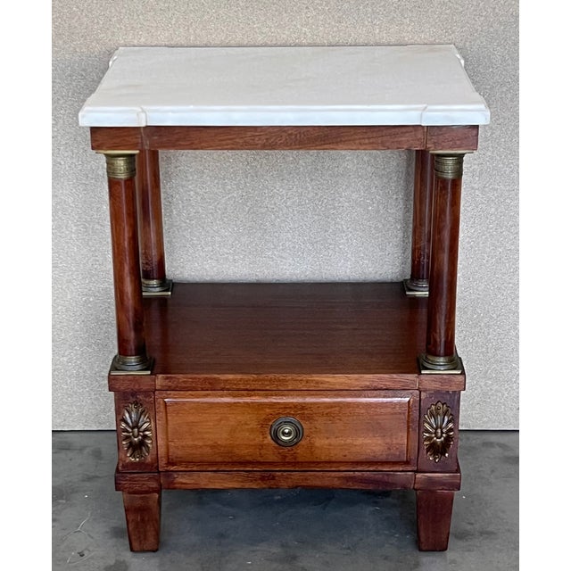 French Empire Solid walnut wood. Gilded and chiselled fittings. Two-wise frame base with protruding rectangular marble...