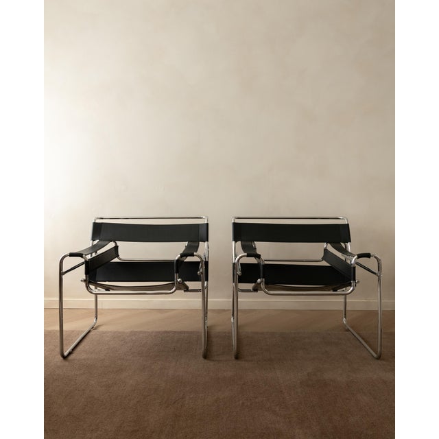 A vintage pair of wassily b3 lounge chairs in black leather and chrome-plated tubular steel, designed by marcel breuer and...