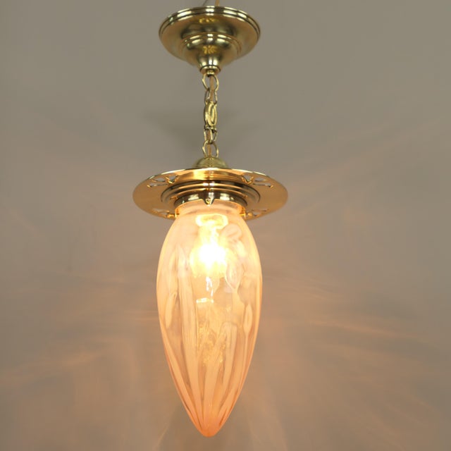 Rose-coloured Art Nouveau shade with floral pattern, 1910s The surface of the brass holder is polished. Total height with...