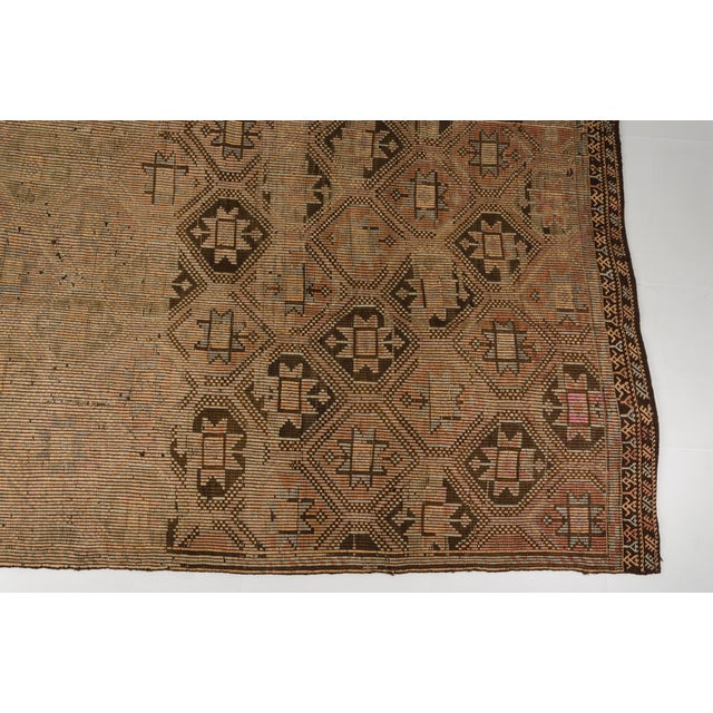 This is a vintage Turkish Oushak rug from the Mid 20th Century. The piece was hand-knotted.