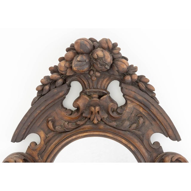 Black Forest Carved Walnut Wall Mirror, 19th century, with circular mirror surrounded by floral motif and fruit basket...