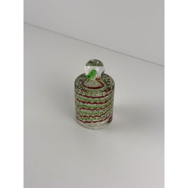 This Fratelli Toso Murano glass paperweight, dating from the 1960s, combines bullicante decoration with red and green...