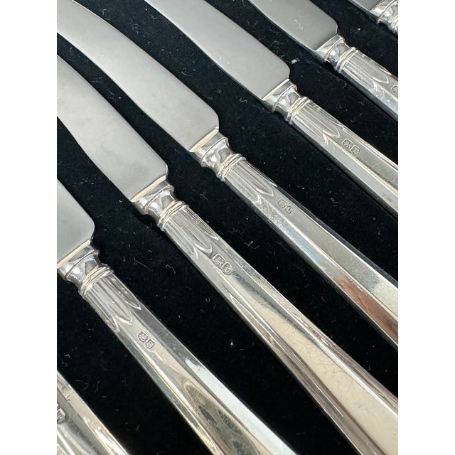 Two cased sets of silver-handled fruit knives and forks. Each set consists of six knives and six forks, presented in a...