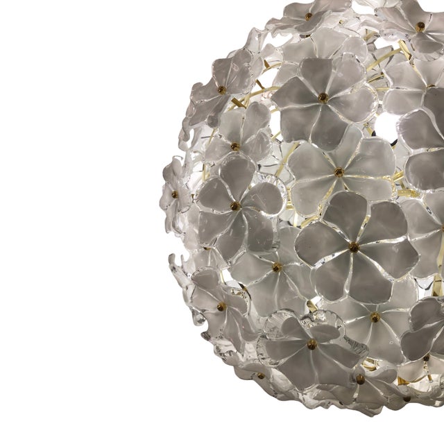 This stunning ceiling lamp is composed of white and clear crystal flowers mounted on a gilded spherical structure. The...