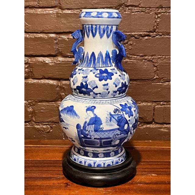 Up for listing is a striking 15-inch Chinese blue and white porcelain double gourd vase featuring dual molded dragon-form...