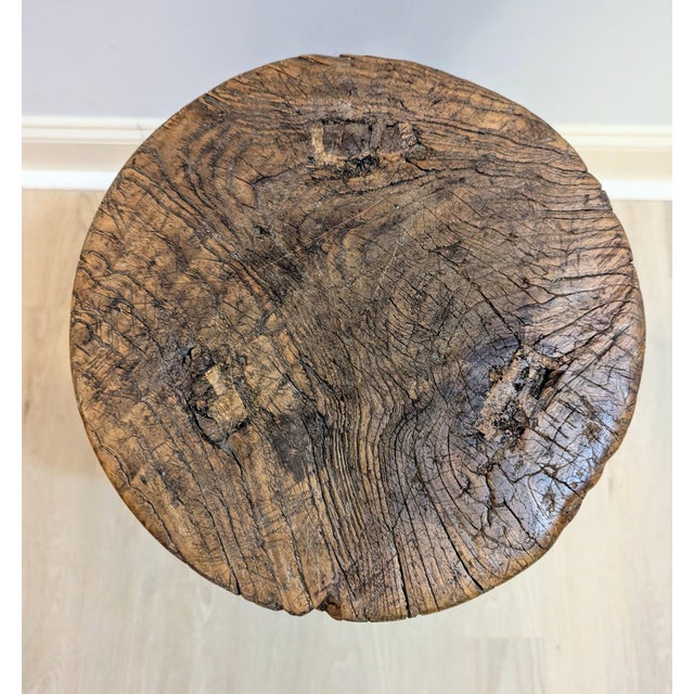 An exceptional, authentic early 20th-century Chinese provincial tri-leg milking stool crafted from aged old-growth...