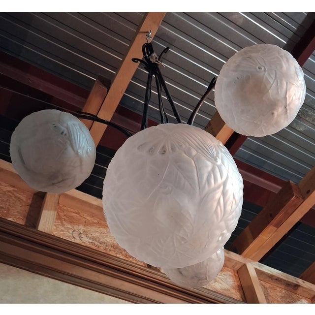 According to muller: an art deco four-light chandelier, dating from the 1920s-1930s, combining an elegant patinated...