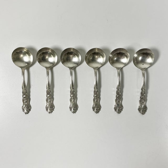 This set of six silverplated dessert spoons are from the 1930-40s era. They feature a deep round spoon cup and grape...