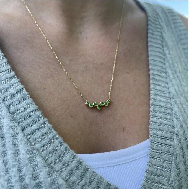 This playful pendant features 7 all natural tsavorite center stones in solid 14k yellow gold with a solid 14k yellow gold...