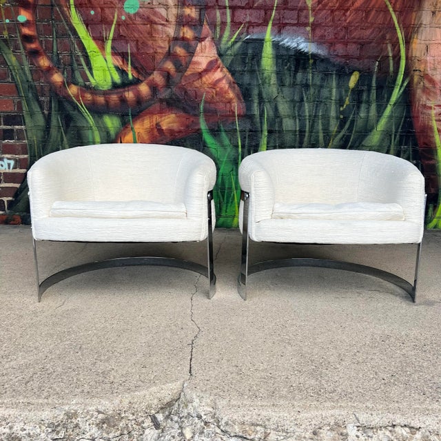 Striking pair of vintage cantilevered barrel-back club chairs, often attributed to Milo Baughman, featuring sleek chromed...