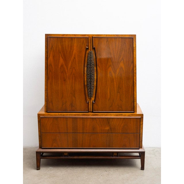 A mid century tallboy chest of drawers by Genova Furniture Company. A warm lacquered walnut finish, burl wood accents,...