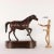 Carved wooden horse covered in leather on a coeval base. The attention to detail highlights the good sculptural skills of...