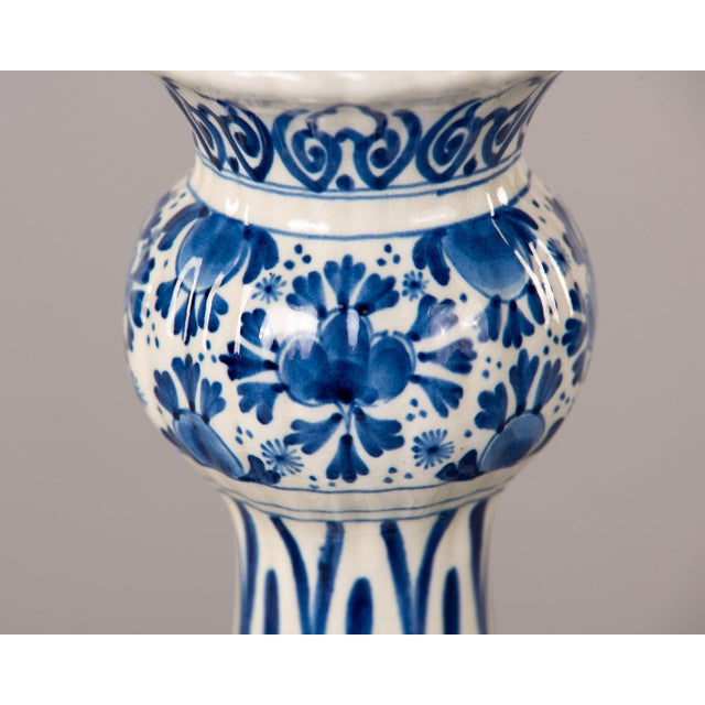 This Dutch Delft vase follows the classic garlic neck form, its bulbous body rising through a slender fluted neck to a...