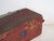 Antique rustic red-painted trunk, of elongated rectangular form and flat hinged lid on forged pin hinges, with block-...