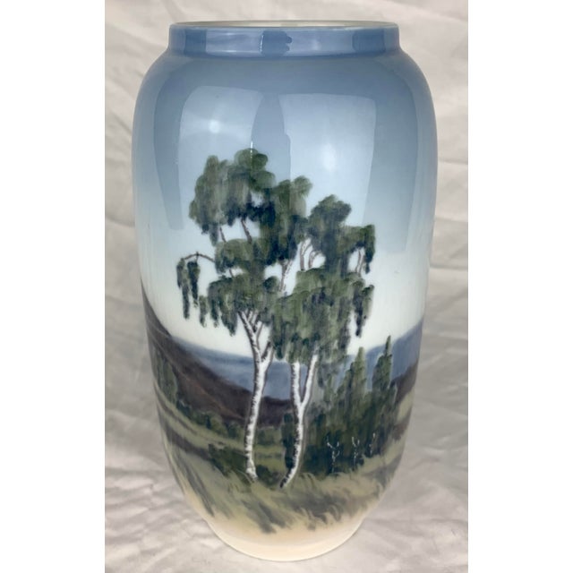 This is a vintage Royal Copenhagen porcelain Art Nouveau vase (model 2889/107) featuring a hand-painted idyllic landscape...