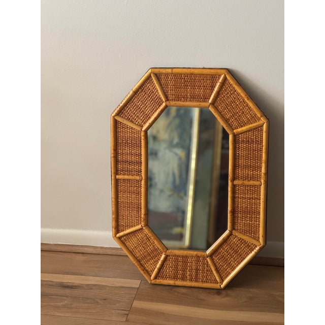 Mid 20th century octagonal wall mirror with a faceted frame executed in woven reed and rattan.