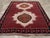 This wool pile carpet, woven with symmetric knots on a wool foundation, is nearly square in shape. It features two...