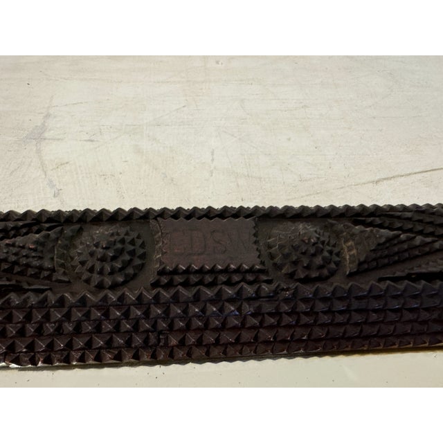 This is an intricately carved wooden mirror dating back to 1899. The frame exhibits a dark, rich finish, highlighting the...