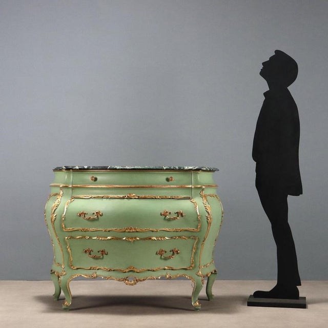 Late Baroque-style lacquered and gilded chest of drawers. Alpi green marble top, drawer in the band below the top, and two...