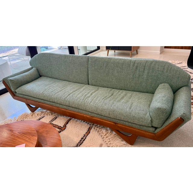 Beautiful Mid-Century Modern gondola-style sofa featuring a striking sculptural solid walnut base and legs. This is a...