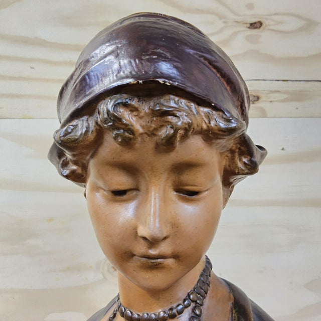 DESCRIPTION: Beautiful antique Art Nouveau bust of a young woman wearing a headscarf and necklace. The statue has a...
