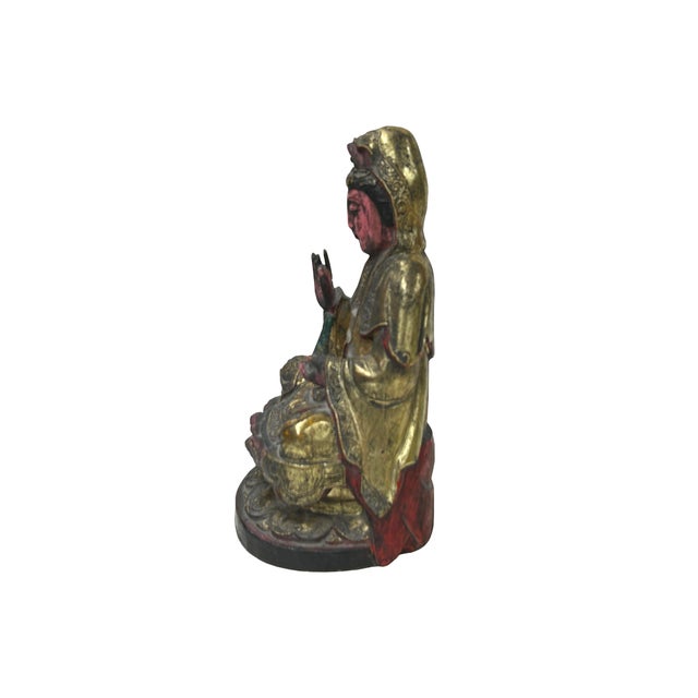 This vintage Chinese wooden carving depicts Kwan Yin, the Bodhisattva of Compassion, seated in a serene meditative pose...
