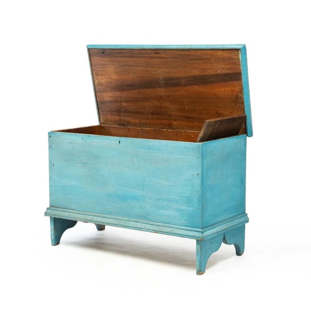 Early American blanket chest in original blue painted finish. This stunning example has an overhanging lid with thumb-...