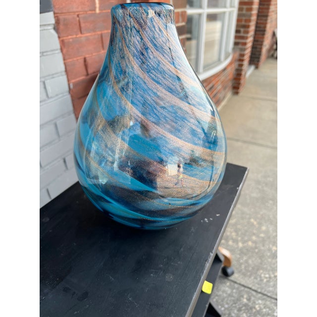 Teal Swirled Glass Vase with hints of Gold throughout . Measures almost a Foot tall.