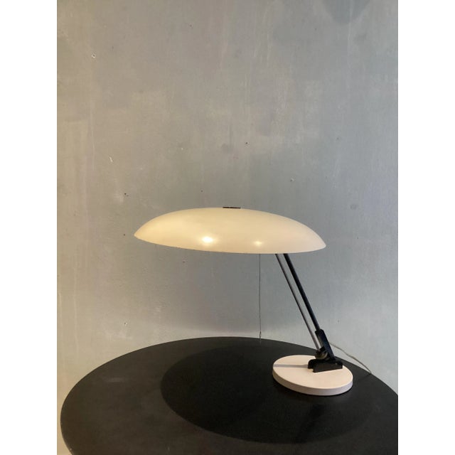 Striking minimal shaped metal table light. This elegant and quite large desk lamp displays the exemplary talent of the...