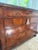 Louis Philippe console chest or commode from France, with a black marble top and a veneer of burled walnut. A tasseled key...