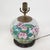 This vintage table lamp is repurposed from an authentic white porcelain vase featuring a lush Famille Rose botanical...