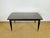 An elegant 1950s modernist dining table, crafted from dark precious wood veneer, specifically macassar ebony, offering...