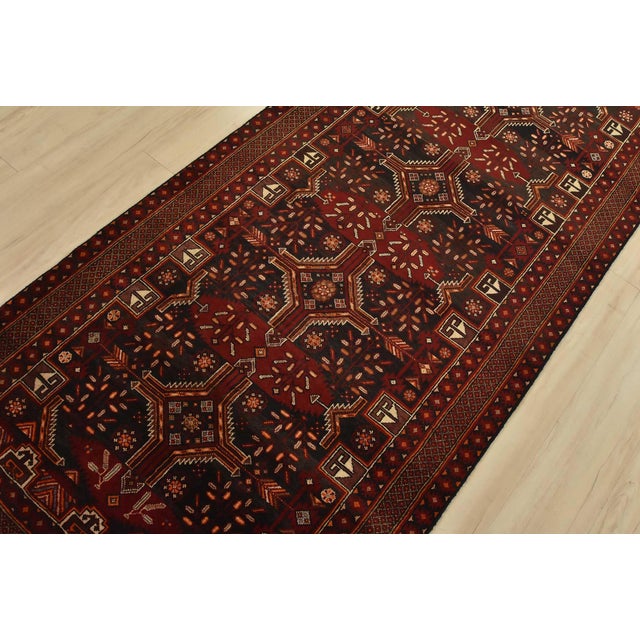 An authentic vintage tribal Baloch runner hand-knotted with fine wool and natural dyes. This nomadic rug features...