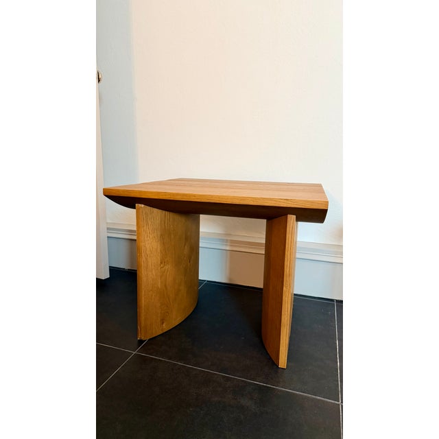 A shape-driven end table made from thick-cut oak veneer features overscale proportions and half-moon shaping in a warm...
