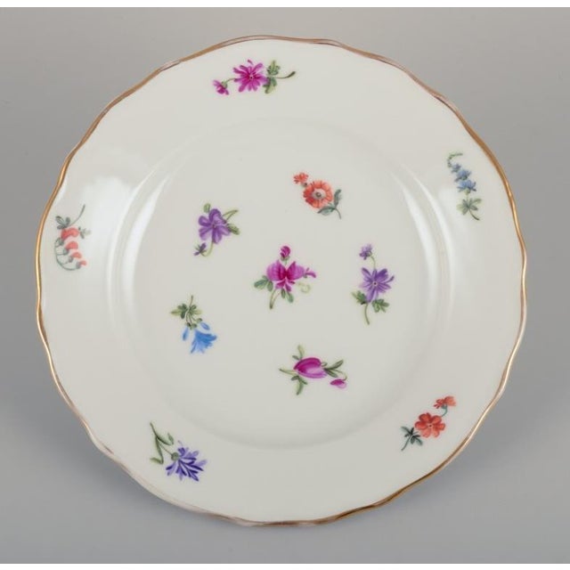 Silesia, Germany. Six small porcelain lunch plates. Hand-painted with floral motifs in polychrome colors, gold rim....