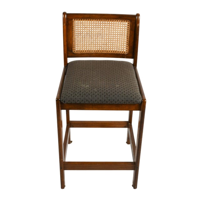 This oak cane back bar counter stool offers a timeless blend of classic craftsmanship and understated elegance. The warm-...