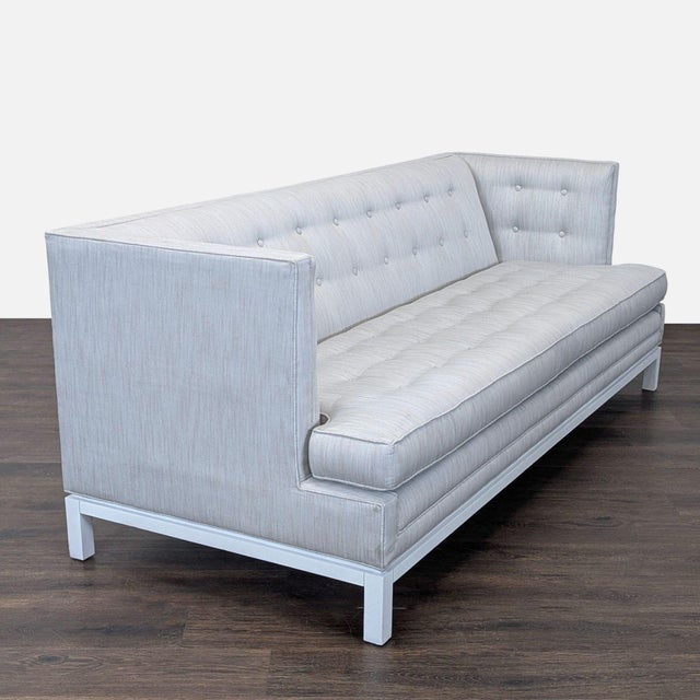 This Jonathan Adler 3-seat sofa features a clean, modern design with light grey upholstery and button tufting on the...