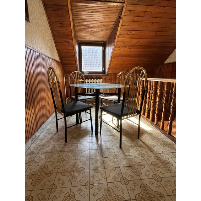 A beautiful vintage dining set for sale, featuring 4 brass-framed chairs with wooden seats and a matching dining table....